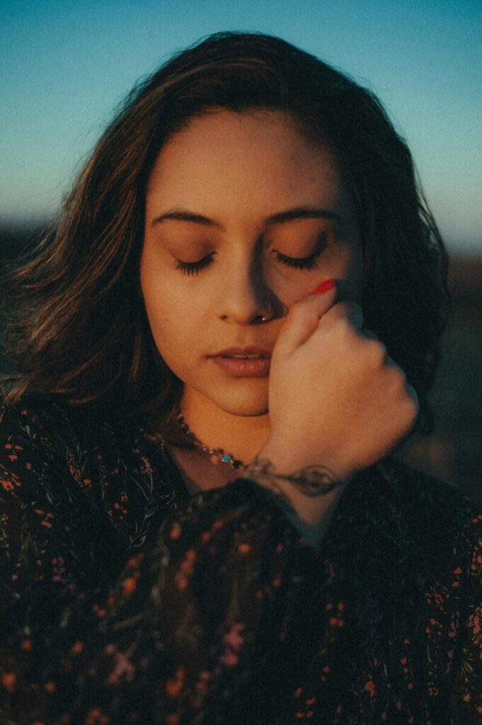 Portrait of a woman in peaceful contemplation outdoors at sunset.